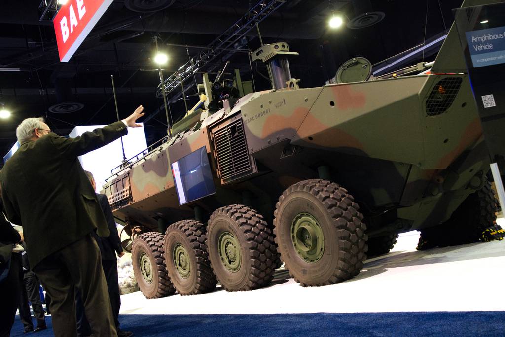 An Amphibious Combat Vehicle, with a TV mounted to its side, sits at the BAE Systems booth at the Sea-Air-Space conference in National Harbor, Maryland, in April 2023.