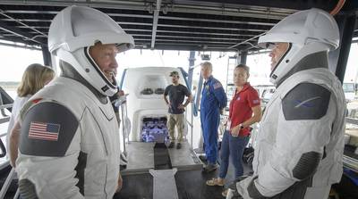 In this Aug. 13, 2019, file photo, NASA astronauts Doug Hurley, left, and Bob Behnken work with teams from NASA and SpaceX to rehearse crew extraction from SpaceX's Crew Dragon at the Trident Basin in Cape Canaveral, Fla.