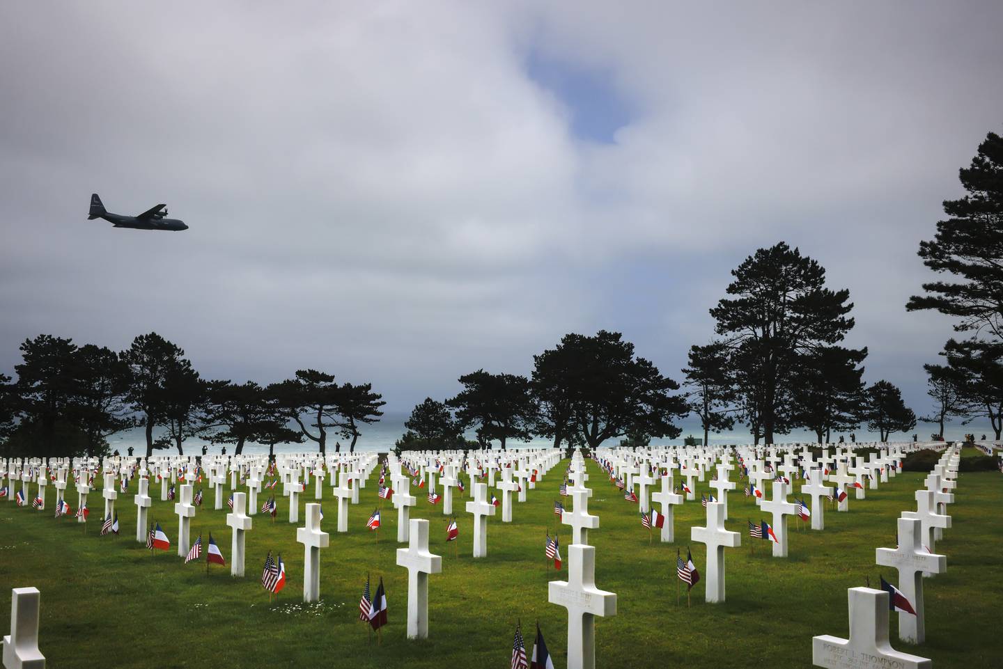 A plane flies over the American Cemetery in Colleville-sur-Mer, Normandy, Monday June 5, 2023.