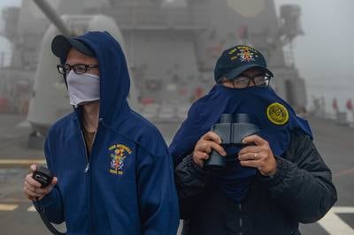 Logistics Specialist 3rd Class Tyler Stidham, left, and Logistics Specialist 3rd Class Rhandy Domigpe stand low visibility watch aboard the Arleigh Burke-class guided-missile destroyer USS Russell (DDG 59) on May 15, 2020, in the East China Sea.