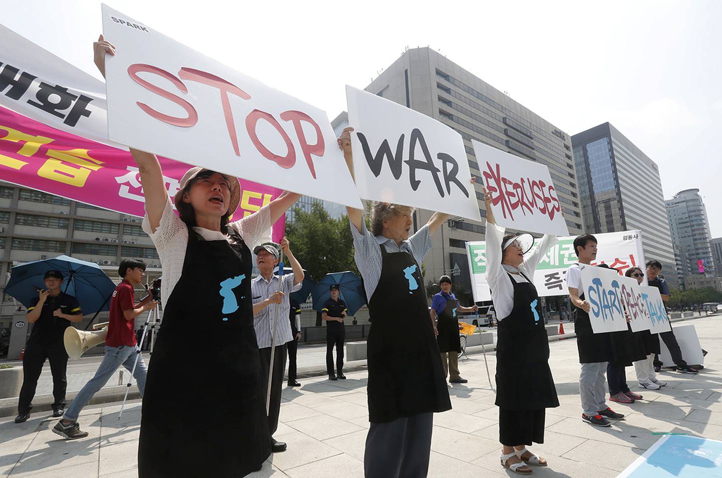 Protesters hold up placards to oppose planned joint military exercises between South Korea and the United States near the U.S. Embassy in Seoul