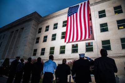 A Pentagon crew unfurls an American flag at dawn on the 18th anniversary of the 9/11 attacks at the Pentagon, Sept. 11, 2019.