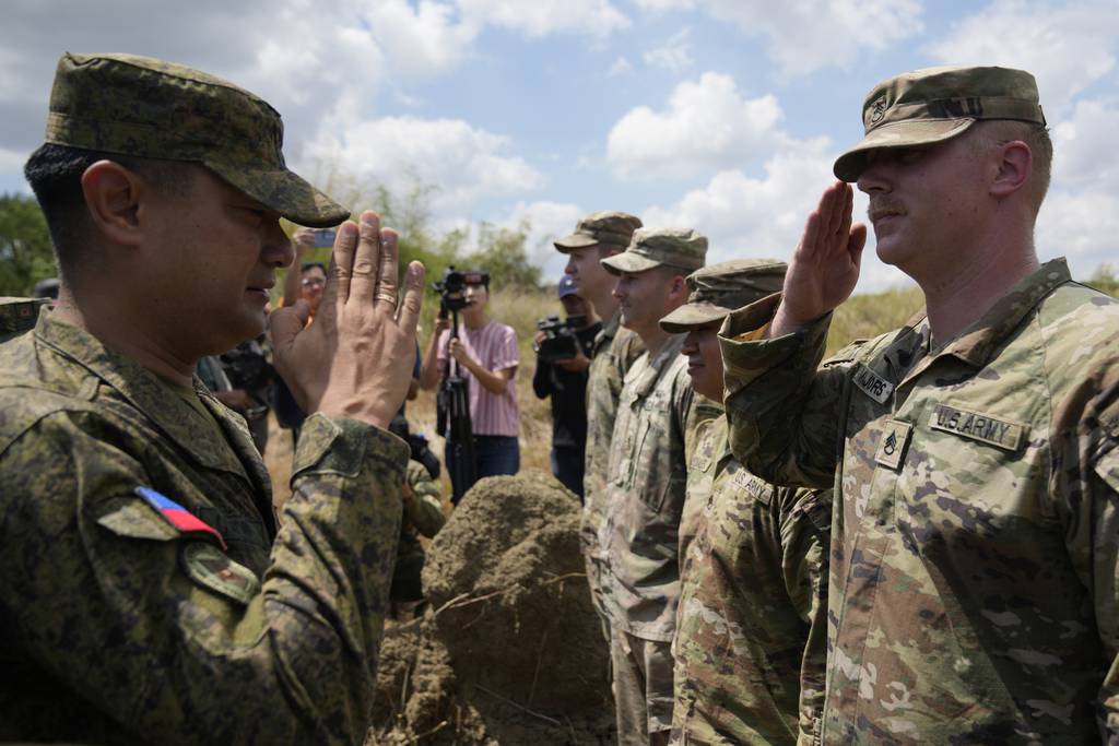 Philippine Army Artillery Regiment Commander Anthony Coronel, left, returns a salute from a US soldier during a joint military drill called Salaknib at Laur, Nueva Ecija province, northern Philippines on Friday, March 31, 2023.