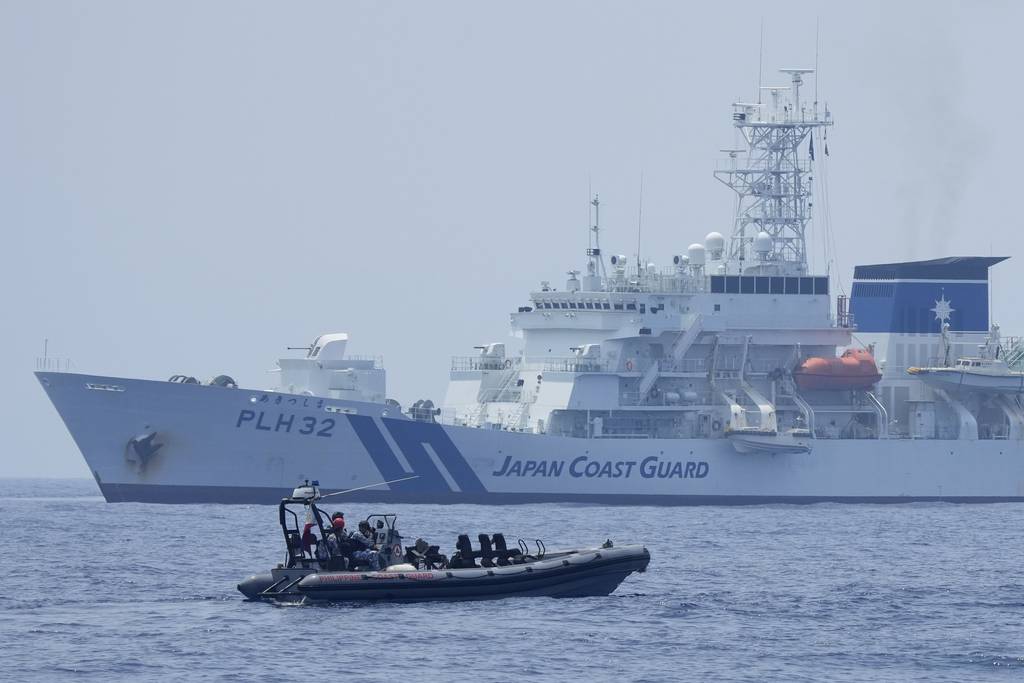 A Philippine Coast Guard rigid hull inflatable boat passes by the Japanese Coast Guard Akitsushima during a trilateral Coast Guard drill of the U.S., Japan and Philippines, near the waters of the disputed South China Sea in Bataan province, Philippines, Tuesday, June 6, 2023.