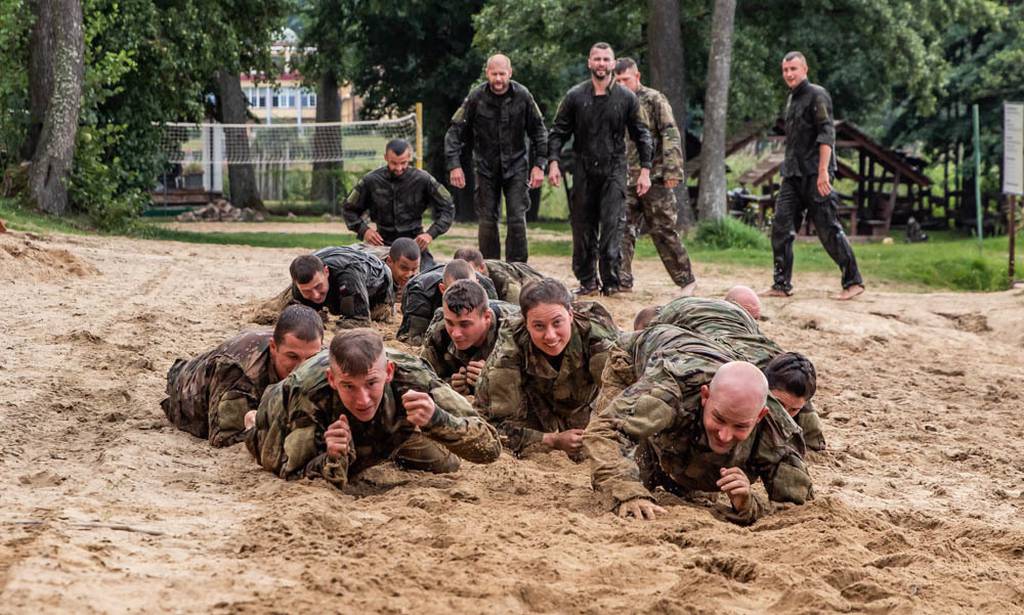 Soldiers from 278th Armored Cavalry Regiment along with Polish soldiers low crawl in the sand during day two of training for the water wurvival course hosted by 15th Mechanized Brigade in Gizycko, Poland, Aug. 12, 2019.