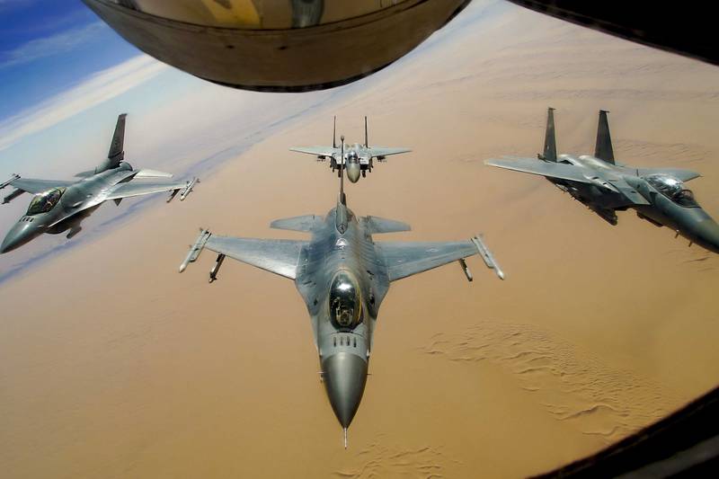 Two U.S. Air Force F-16 Fighting Falcons fly in formation with two Royal Saudi Air Force F-15E Strike Eagles after receiving fuel from a KC-135R Stratotanker during a routine exercise over Southwest Asia, Dec. 15, 2020.