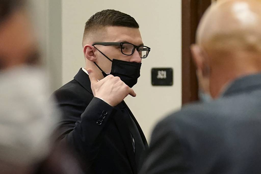 Volodymyr Zhukovskyy raises his hand while departing a courtroom at Coos County Superior Court in Lancaster, N.H., Tuesday, July 26, 2022.