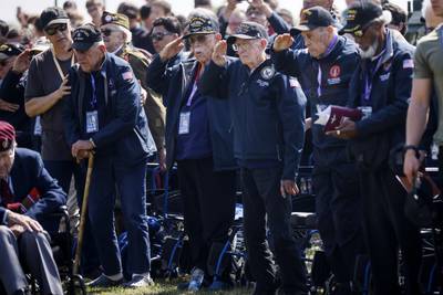 U.S war veterans salute during a ceremony outside the Pegasus Bridge memorial in Benouville, Normandy, Monday, June 5, 2023.