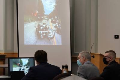 Volodymyr Zhukovskyy is seated with defense attorneys Jay Duguay and Steve Mirkin as an image from the scene of a 2019 crash is projected on a screen during Zhukovskyy's trial at Coos County Superior Court, in Lancaster, N.H., Tuesday, July 26, 2022.
