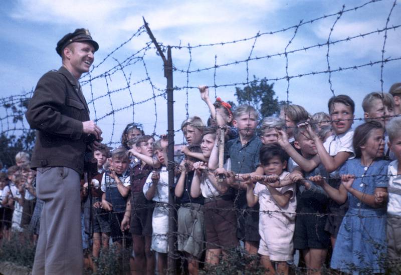 Col. Gail Halvorsen, the "Berlin Candy Bomber," greets children at a barbed wire fence at Tempelhof Airport in Berlin, 1948.