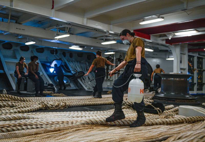 Boatswain’s Mate Seaman Alexis Bias, assigned to the aircraft carrier USS Theodore Roosevelt (CVN 71), disinfects mooring line on May 21, 2020, following an extended visit to Guam in the midst of the COVID-19 global pandemic.