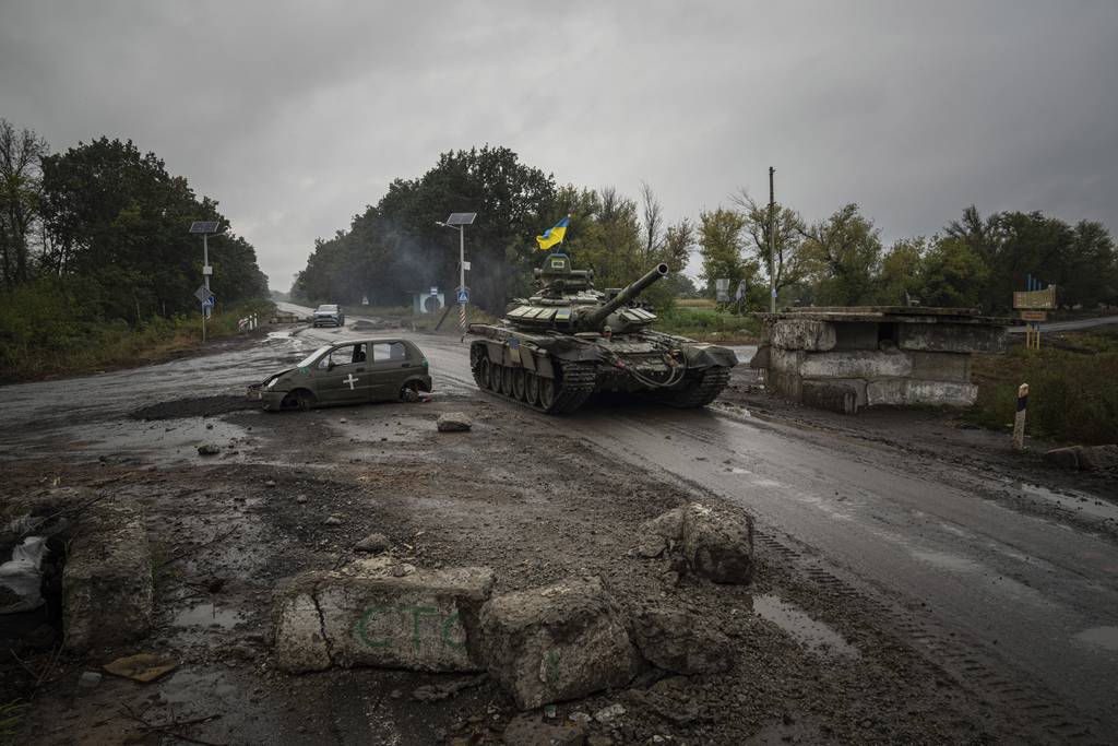 A Ukrainian tank drives past former Russian checkpoint in the recently retaken area of Izium, Ukraine, Friday, Sept. 16, 2022.