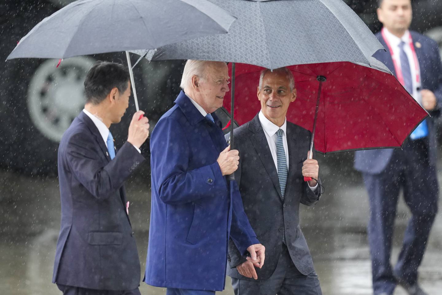 U.S. President Joe Biden, center, walks with Kenji Yamada, Japanese deputy minister of foreign affairs, left, and U.S. Ambassador to Japan Rahm Emanuel, right, after his arrival at Marine Corps Air Station Iwakuni, western Japan, Thursday, May 18, 2023, en route to Hiroshima for the Group of Seven nations' summit that starts Friday.