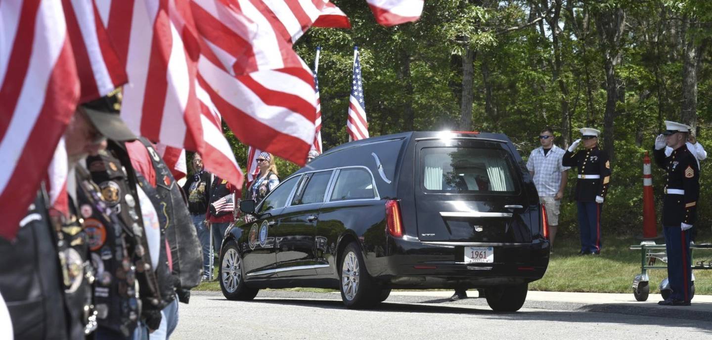 Members of the Patriot Guard Riders line the roadway as the hearse arrives at the National Cemetery in Bourne, where Marine Corps veteran Michael Ferazzi was buried on Friday afternoon.