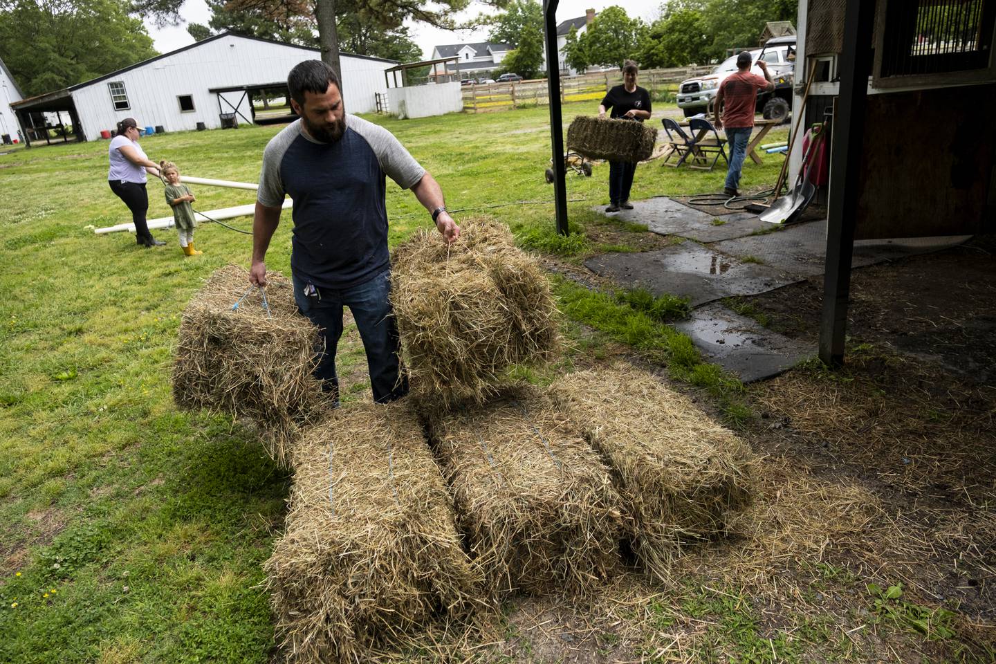 Jarred Bragg helps move bales of hay during a clean up event for Trails of Purpose, May 20, 2023, in Chesapeake, Va., ahead of the opening of their new location in Virginia Beach, Va.