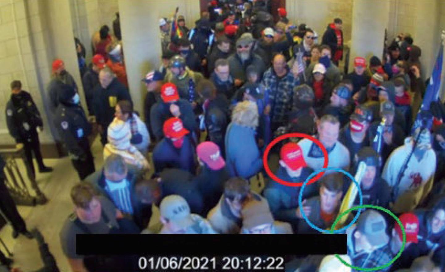 In this image from U.S. Capitol Police video, released and annotated by the Justice Department in the Statement of Facts supporting an arrest warrant, Joshua Abate, circled in green, Micah Coomer, circled in red, and Dodge Dale Hellonen, circled in blue, appear inside the U.S. Capitol on Jan. 6, 2021, in Washington.