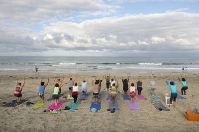 Waves break along the shore as patients yoga during a Naval Medical Center San Diego yoga therapy session on the beach in Del Mar Calif., Sept. 14, 2017.