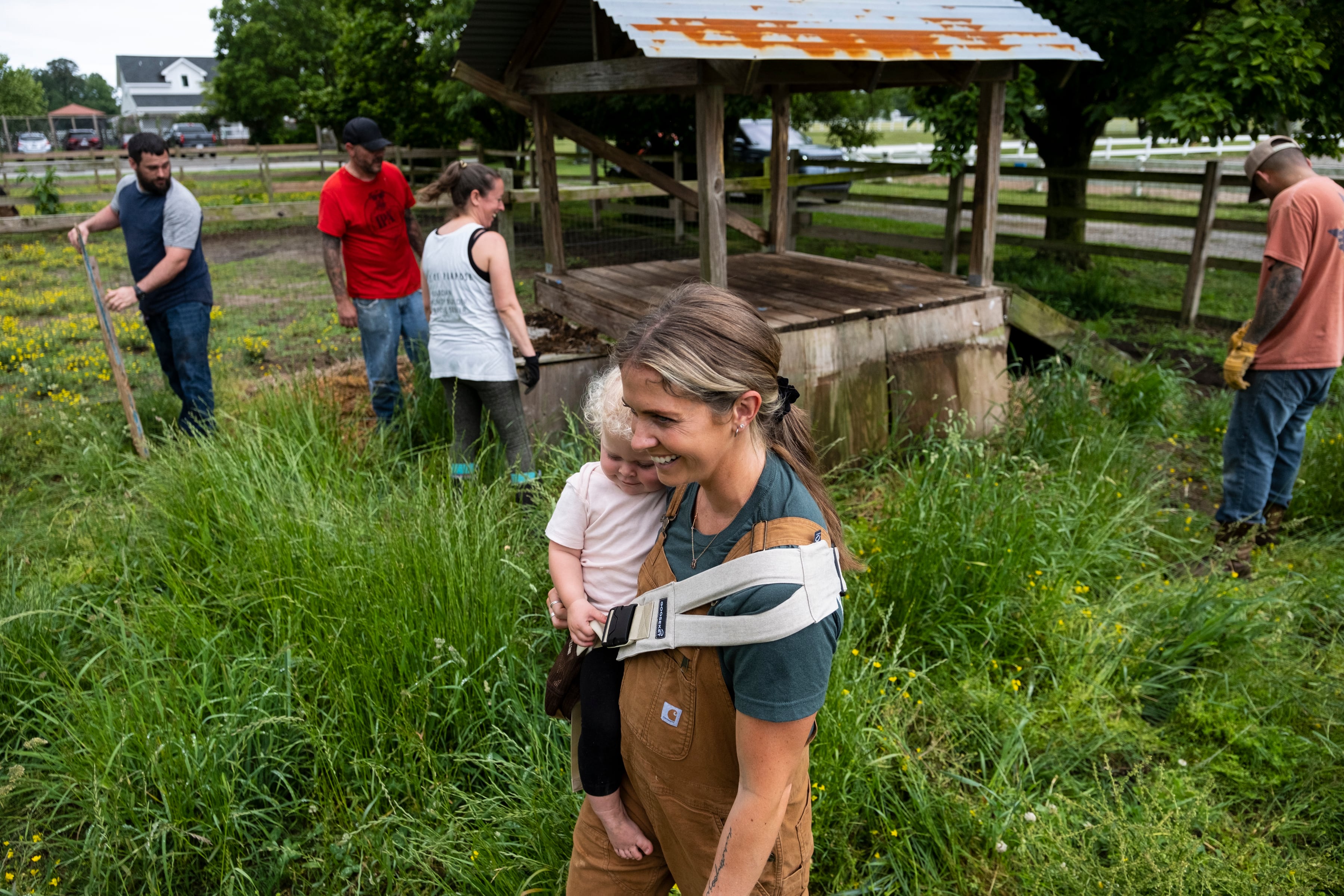Kayla Arestivo, a therapist with Trails of Purpose, watches as volunteers help move bales of hay on May 20, 2023, in Chesapeake, Va., ahead of the opening of their new location in Virginia Beach, Va.