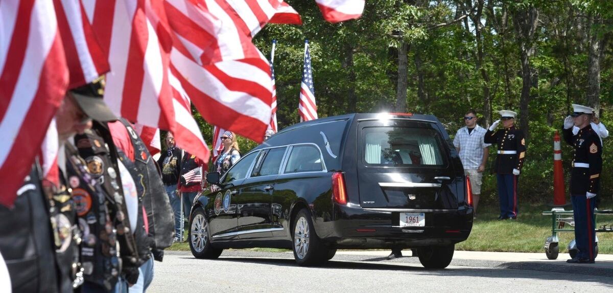 Members of the Patriot Guard Riders line the roadway as the hearse arrives at the National Cemetery in Bourne, where Marine Corps veteran Michael Ferazzi was buried on Friday afternoon.