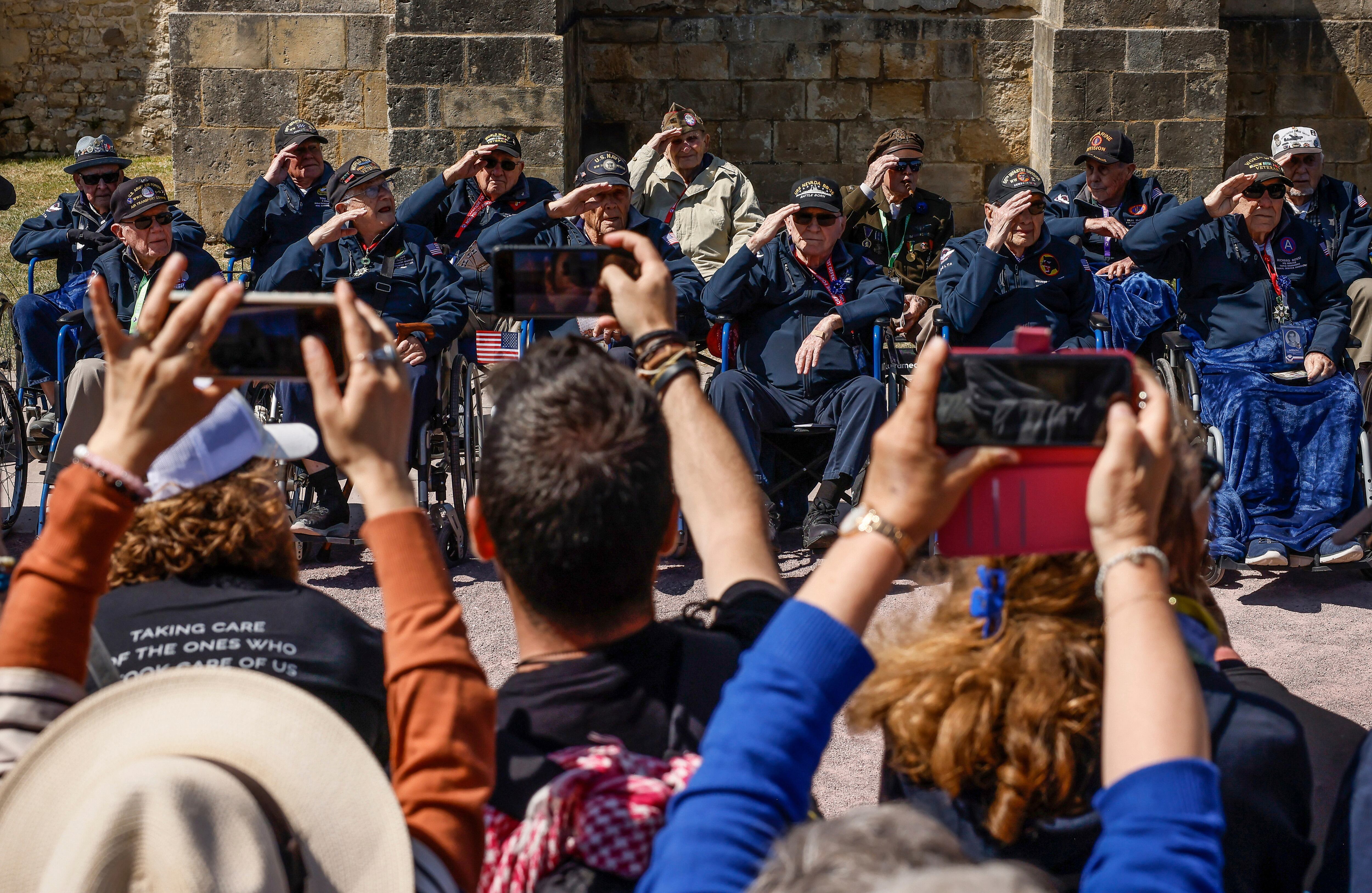 U.S. veterans salute as they pose for photographs after a parade in preparation of the 79th D-Day anniversary in Sainte-Mere-Eglise, Normandy, France, Sunday, June 4, 2023.